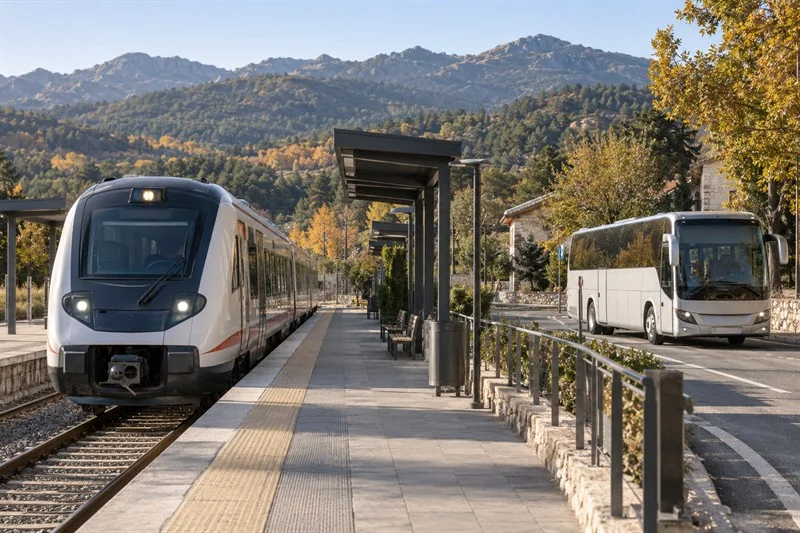 Tren de cercanías y autocar genéricos en una estación representativa junto a la Sierra de Guadarrama.